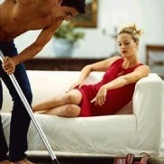 husband does housework while his wife watches from the sofa, house chores, housework porn, half-naked man vacuuming, she's in charge, female-led relationship, the future is female